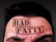 A closeup shot of performer's forehead with text 'Bad Fatty' printed overtop