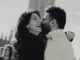 A black and white photo of a man and a woman hugging. She is laughing, and in the background you can see Big Ben.