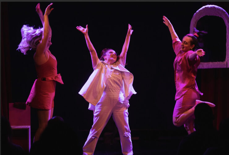 3 women jumping in the air with pink lighting