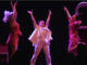 3 women jumping in the air with pink lighting