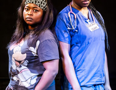 Two women face the camera their backs to each other. Woman on the left is wearing casual clothing and woman on the right wearing scrubs.